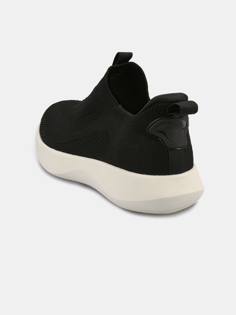 Halti Snabb 2 StepIn miesten mustat slip-on-lenkkarit, joissa on valkoinen pohja, takaa katsottuna vaalealla pohjalla.