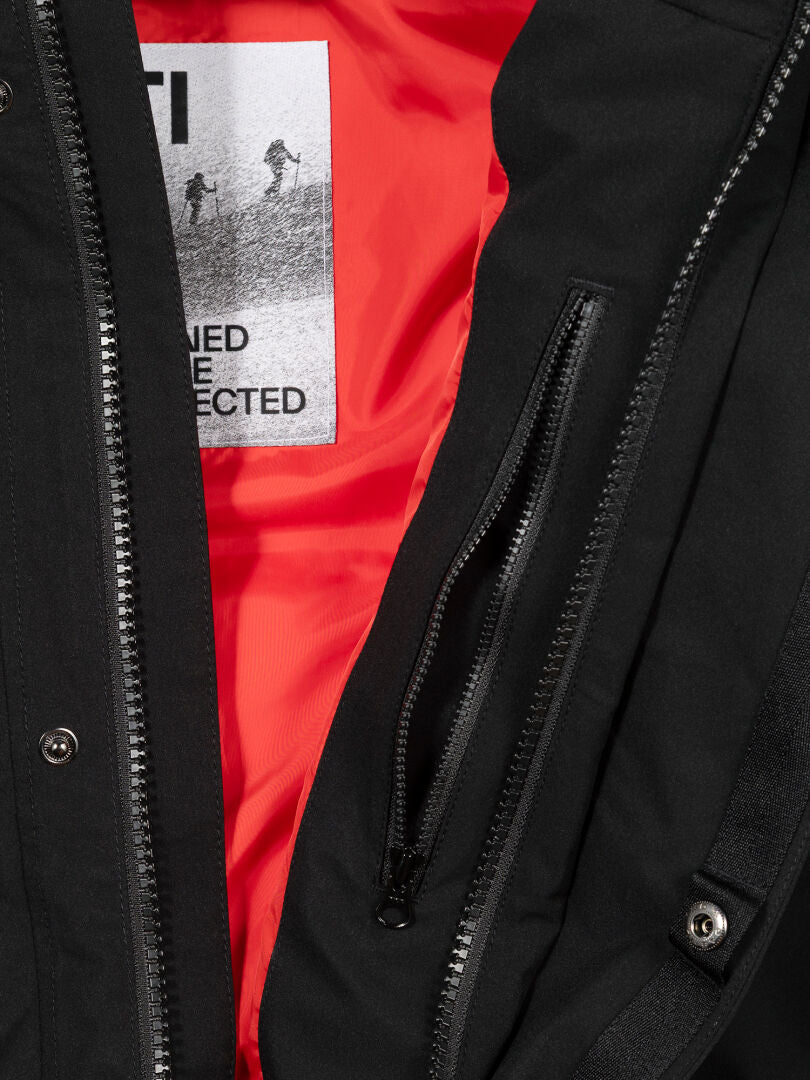 Lähikuva Halti 1976 Down Parka Unisex -takista, jossa näkyvät tämän talvitakin vetoketjut, oranssi vuori ja Halti-merkki.