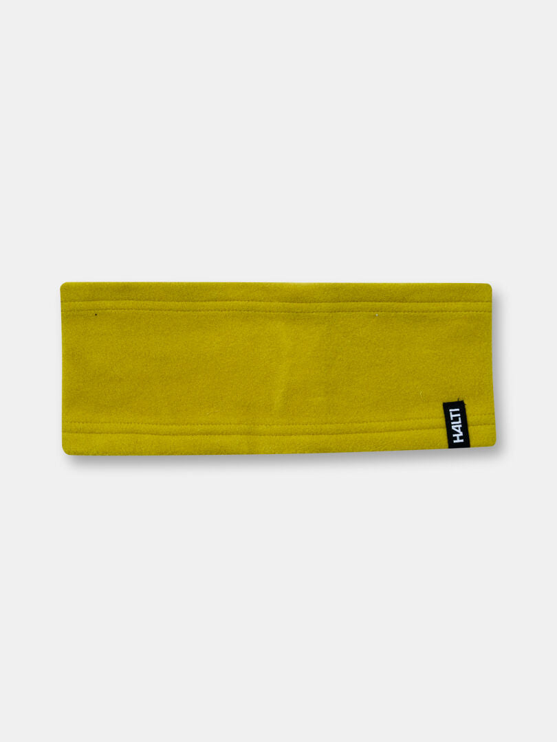 Halti Trone Fleece Panta on keltainen ja siinä on pieni logomerkki, ihanteellinen talvikäyttöön tai aktiiviseen liikuntaan.