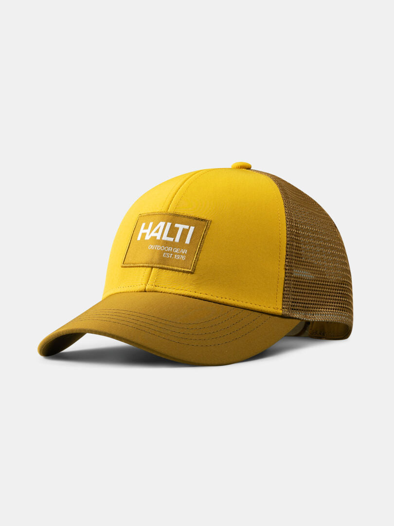 Koskelo Trucker Lippis by Halti on kellanruskea, kierrätettyä polyesteriä, kaarevalla liivillä ja Halti-laastarilla.