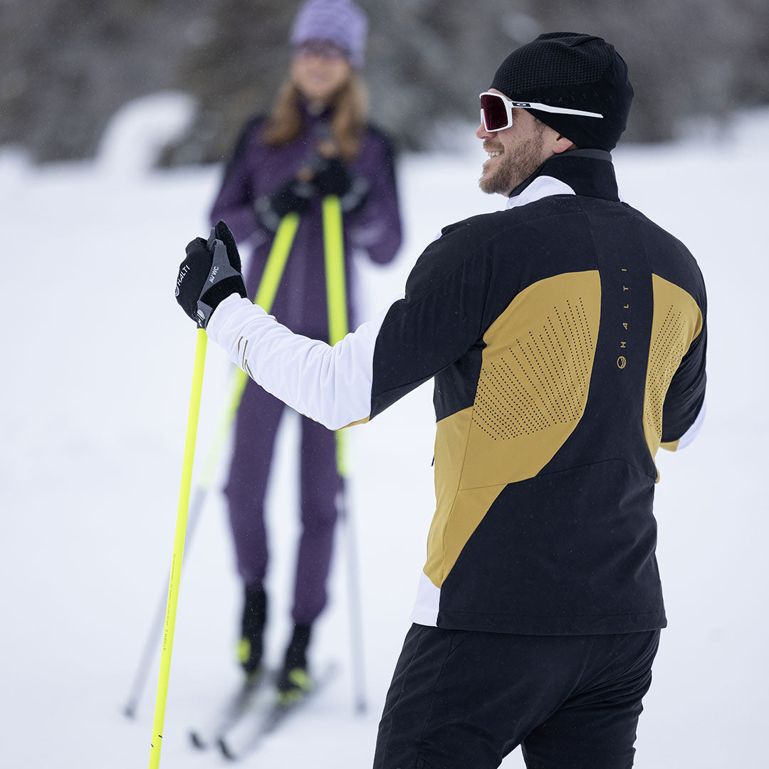 Kaksi henkilöä Halti Veloce Hiihtotakki Miesten Stormwall®-suksilla hiihtää lumisessa maastossa.