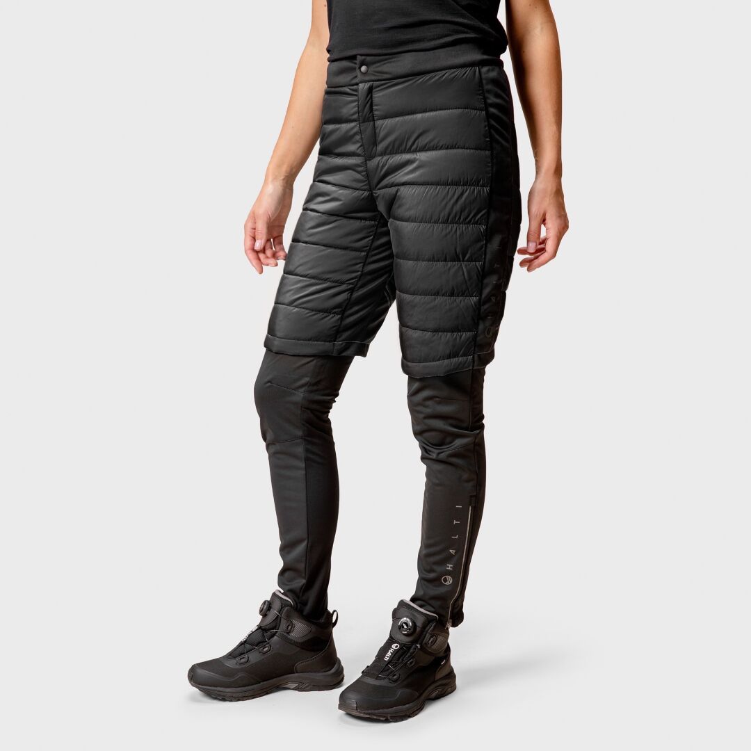 Henkilö Halti Hanki Toppashortsit yli mustat leggingsit ja saappaat, valmis talven aktiviteetteihin.
