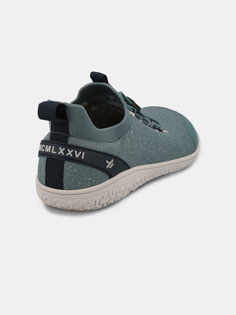 Halti Vire Paljasjalkakenkä Miesten on sininen slip-on, jossa on kuvioitu pohja, vetoketju ja MCMLXXVI kantapäässä.