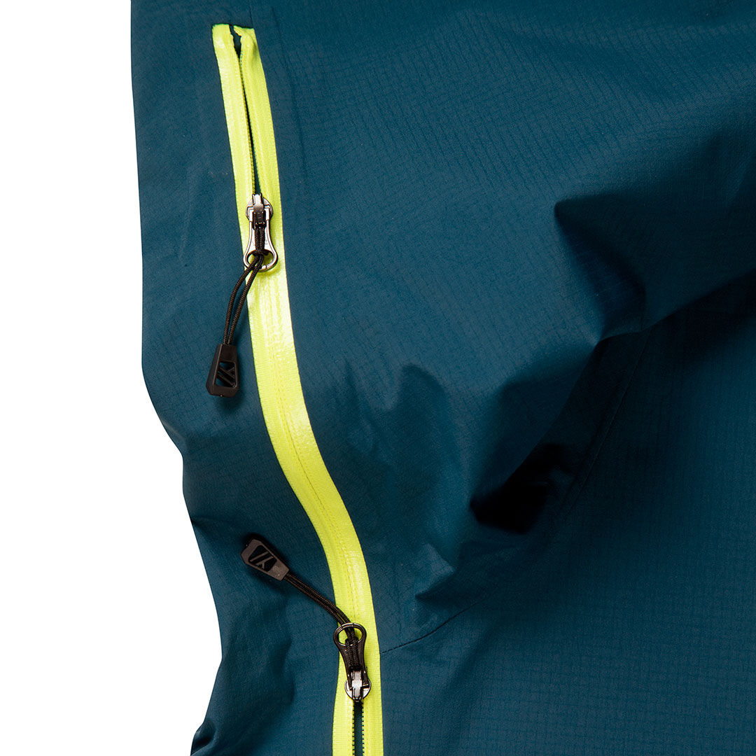 Lähikuva Halti Alpine 3L DX Kuoritakki Unisex hihasta sinisenä, jossa on neonkeltainen vetoketju ja kaksi mustaa vetoketjua.