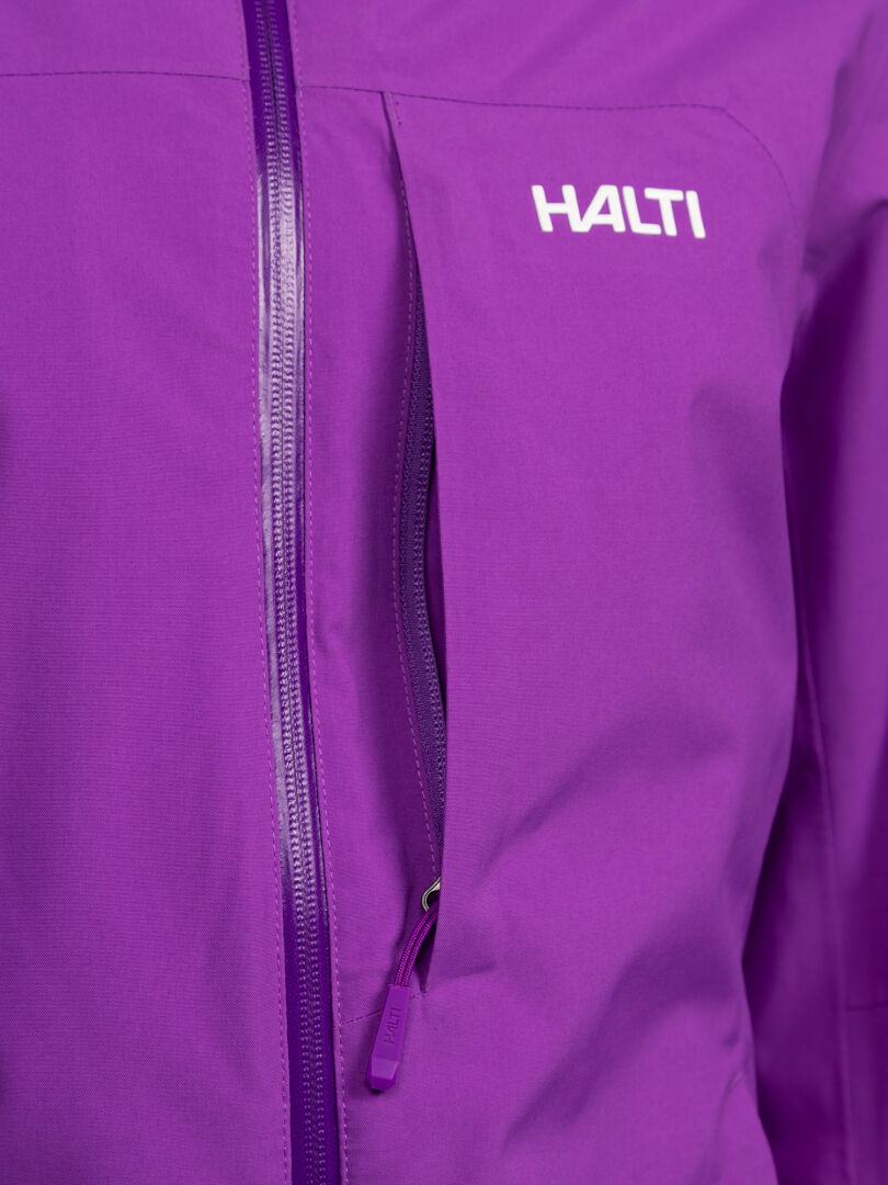 Lähikuva violetista Halti Melvik DX Laskettelutakki Naisten -hiihtotakista, jossa on vetoketjullinen rintatasku ja tuotemerkin logo.