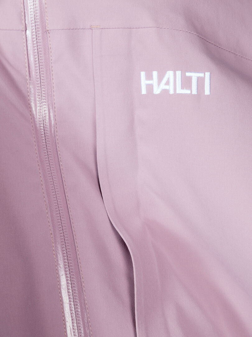 Lähikuva vaaleanpunaisesta Halti Valaja DX Parkatakki Naisten vaatteesta, jossa on vetoketju ja valkoinen Halti-logo rinnassa.