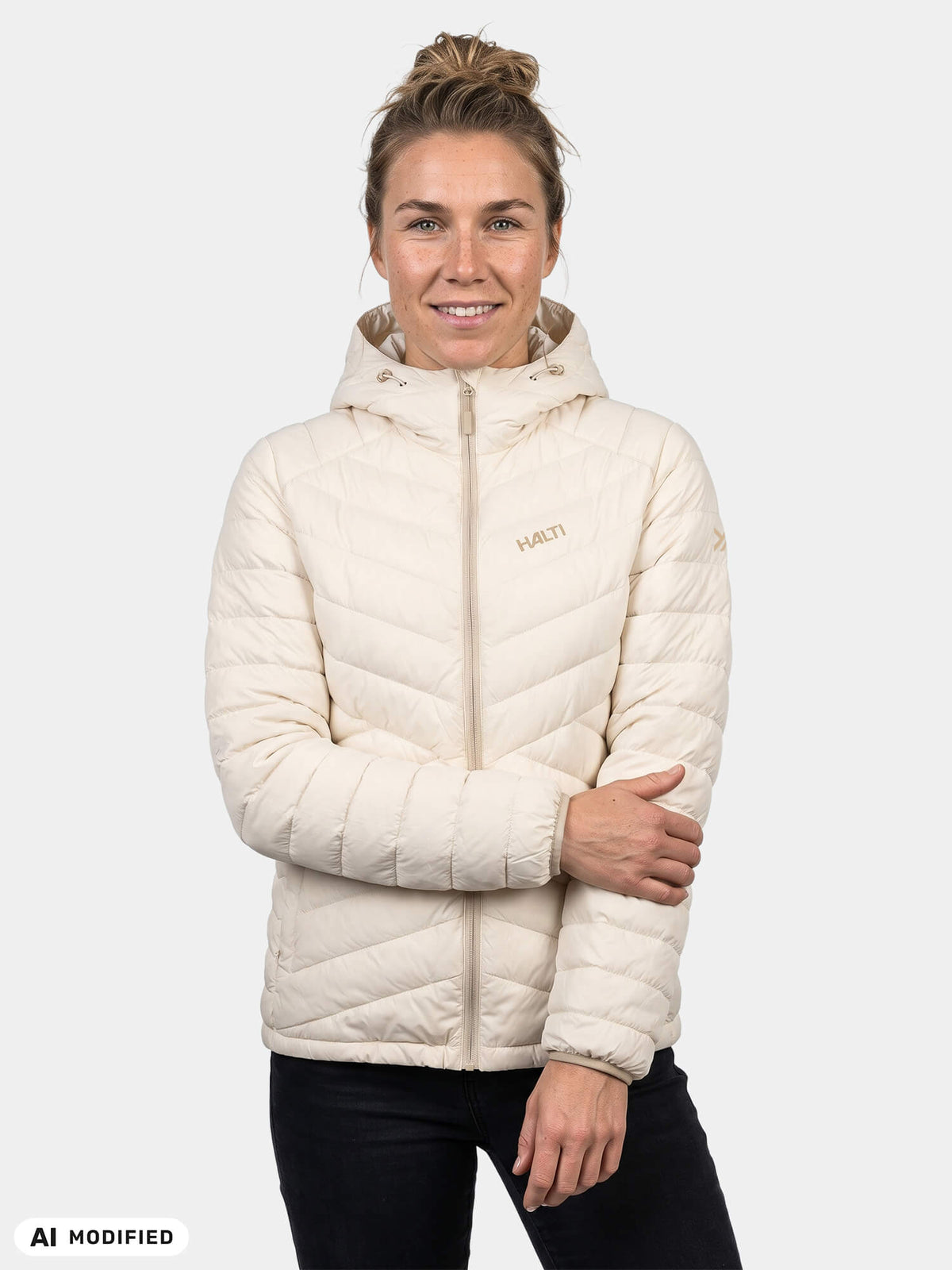 Nainen, jolla on yllään kermanvärinen Halti Huippu Untuvia -untuvatakki (naisten malli).