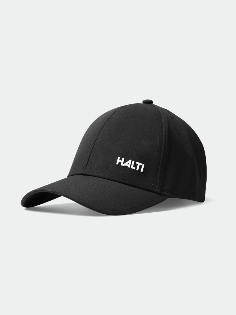 Mattas Baseball-lippis by Halti, musta, valkoinen logo, nopeasti kuivuva stretch-kangas, UPF 50+, vaaleanharmaalla pohjalla.