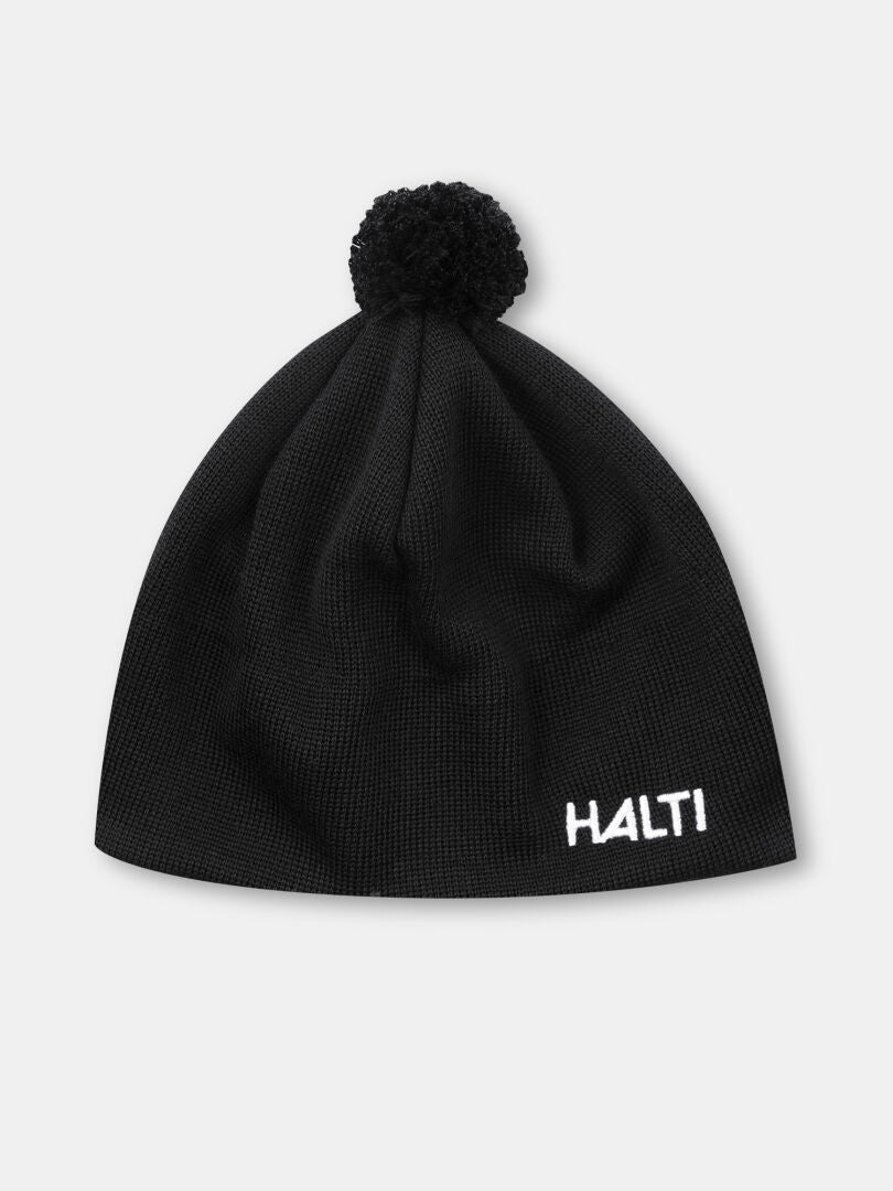 Halti Peesi II Pipo: musta merinovilla pipo, jossa on pompulointi ja valkoinen kirjailtu Halti-logo edessä.