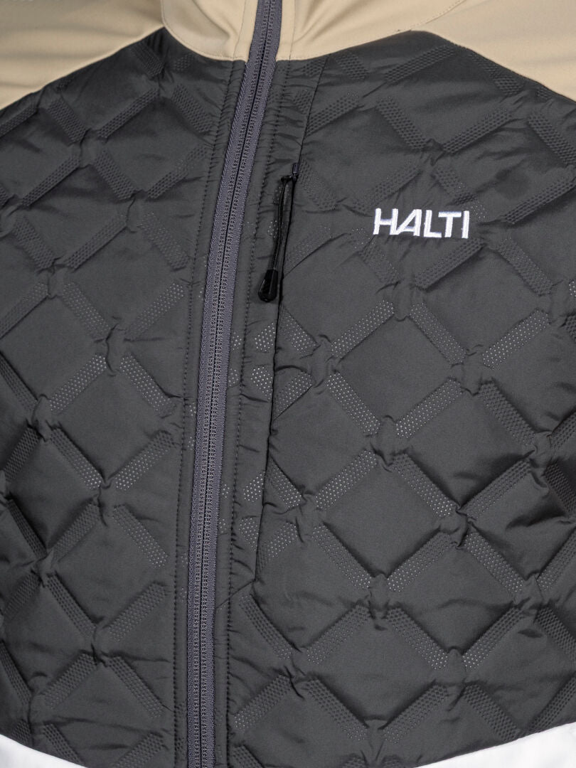 Lähikuvassa Halti Framover Hybrid Hiihtotakki Miesten vetoketju ja valkoinen HALTI-logo rinnassa.