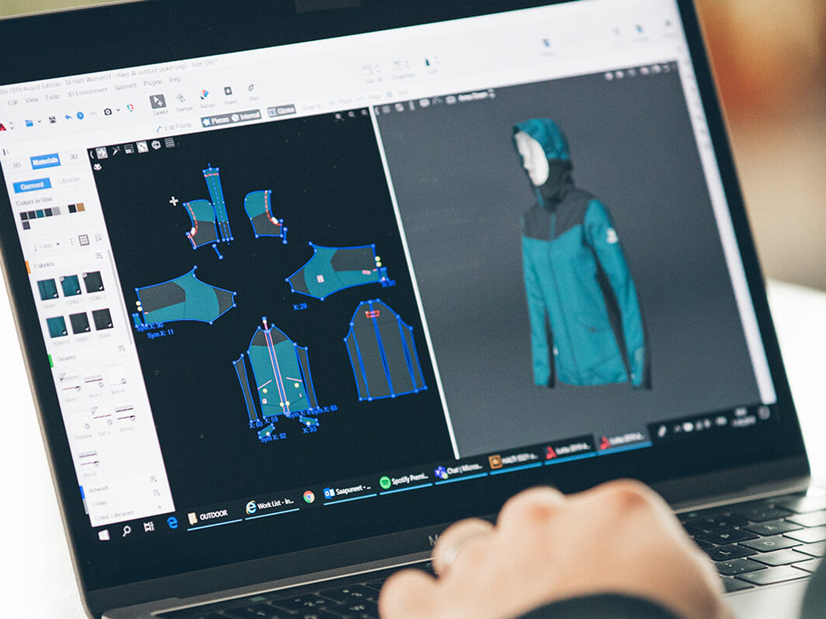 Kannettavan tietokoneen näytöllä näkyy 3D-vaatesuunnitteluohjelmisto, jossa on takin malli ja digitaalinen takkimalli.